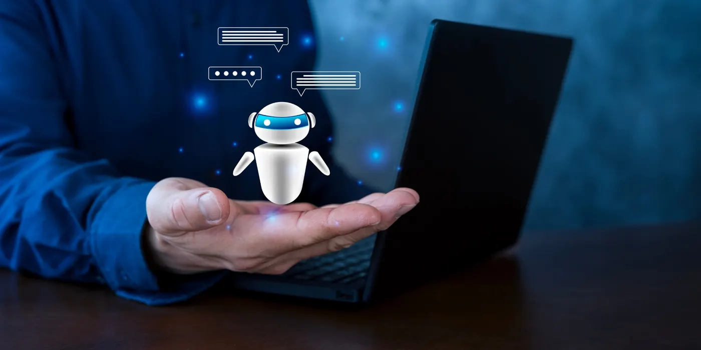 An AI assistant robot hovering above a hand in front of a laptop