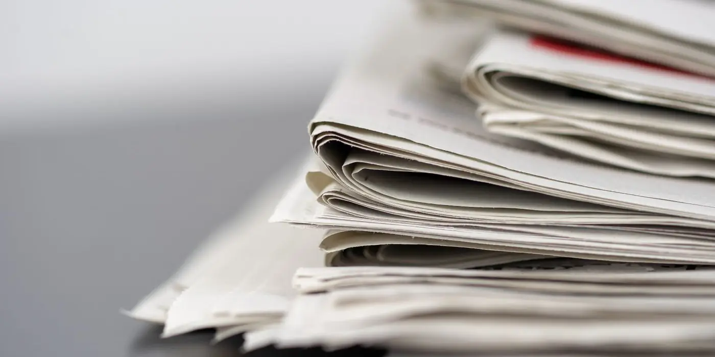 A stack of folded newspapers
